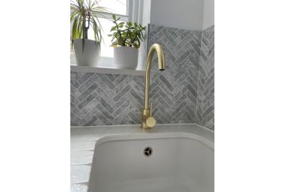 A splashback area with Chicago Honed Marble Chevron Mosaic tiles