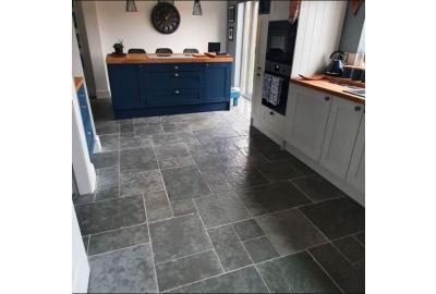A kitchen floor with grey antique limestone flooring