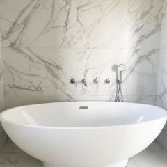 Calacatta grande silk porcelain 600x1200mm floor and wall tiles fitted behind a free standing bath
