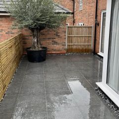 Denver anthracire 600x600mm outdoor porcelain slab tiles fitted on a contemporary patio with arge olive tree