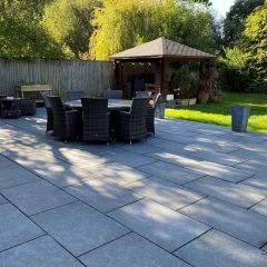 Denver anthracite 600x900mm porcelain slab pictured in a large contemporary garden with seating
