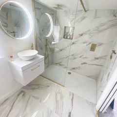 Lavish mirror polished porcelain tiles in a luxury bathroom with gold accessories