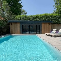 Rustic black split face medium_cladding the outside of an outdoor pool room.