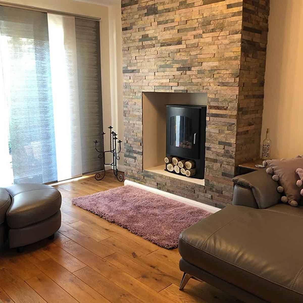 Sheera Split Face Mosaic Tiles cladded on a protruding accent wall surrounding a wood burner 