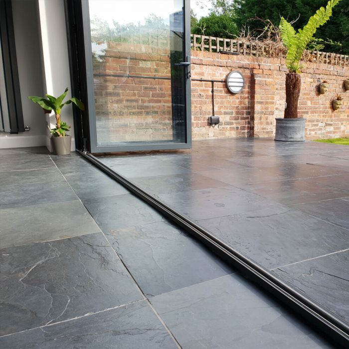 Large format natural black slate tiles in an indoor outdoor environment