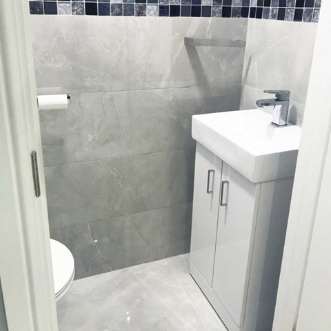 A small bathroom space with Pietra Light Grey Marble Effect Polished Porcelain wall and floor tiles.