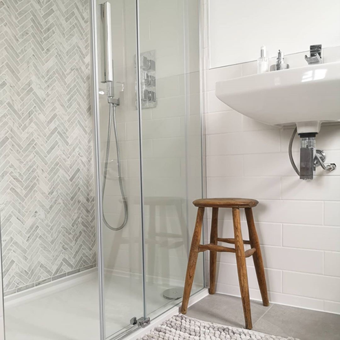 A shower wall with chicago chevron marble brick mosaic tiles