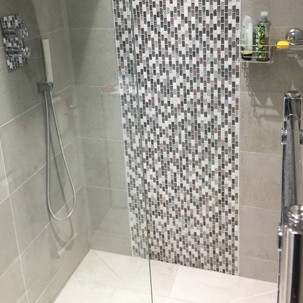 soho stone wall and floor tiles and midas glass and copper mosaic in a shower area