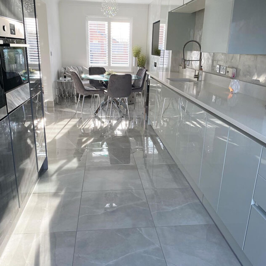 perla soft grey marble effect floor tiles in an open plan kitchen setting 