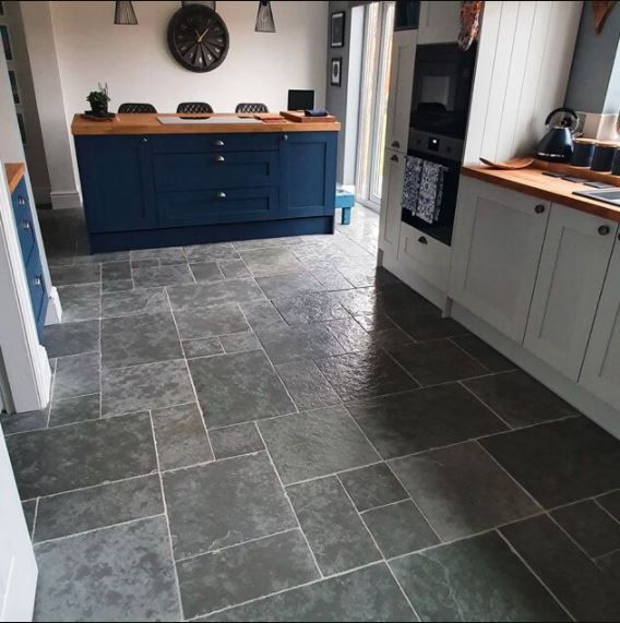A kitchen floor with grey antique limestone flooring