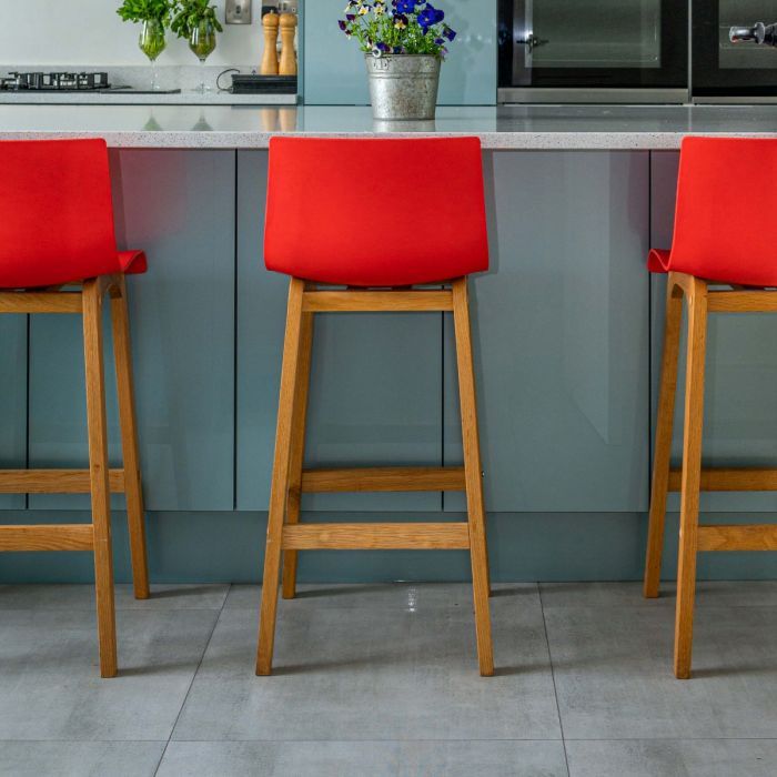 A breakfast bar in a kitchen with indus concrete effect porcelain floor tiles